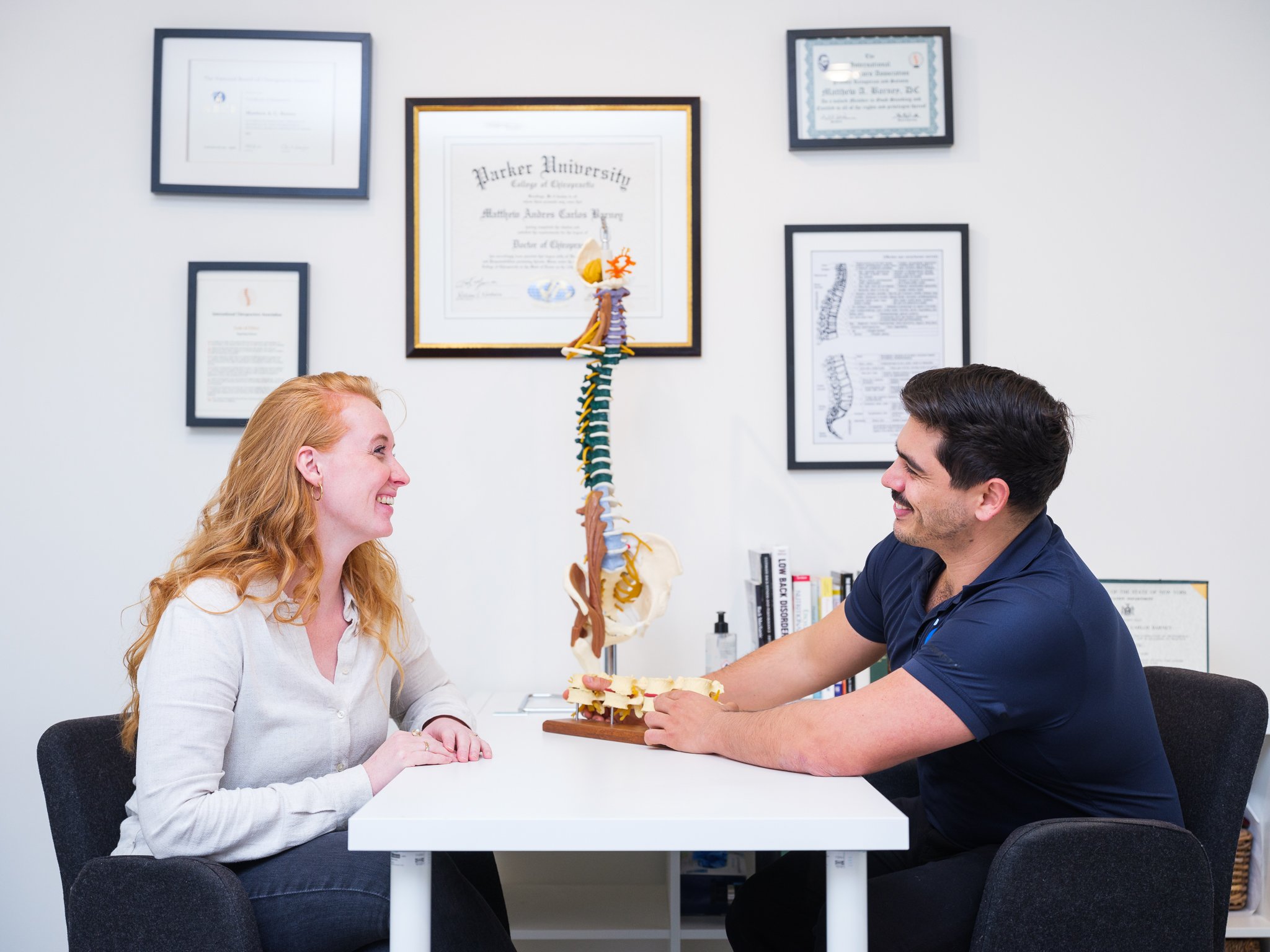 Chiropractor en patiënte lachen tijdens een prettig consult bij Waterland Chiropractie Heusden