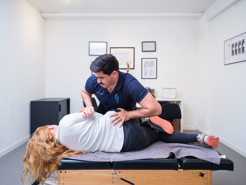 Chiropractor voert een manipulatie uit op de onderrug van een patiënt in de behandelkamer van Waterland Chiropractie Heusden
