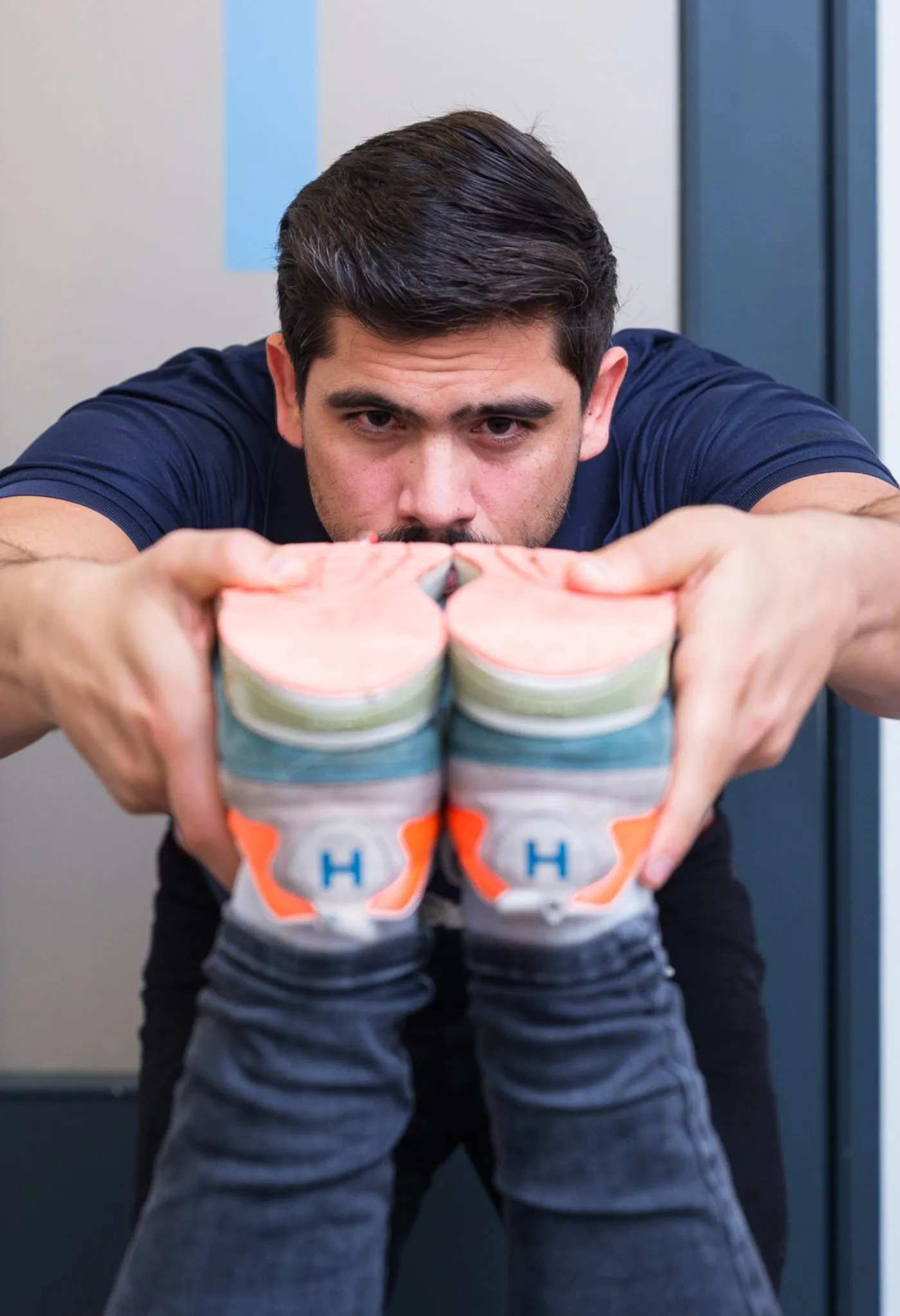 Chiropractor van Waterland Chiropractie Heusden toont zijn sportschoenen in de praktijk